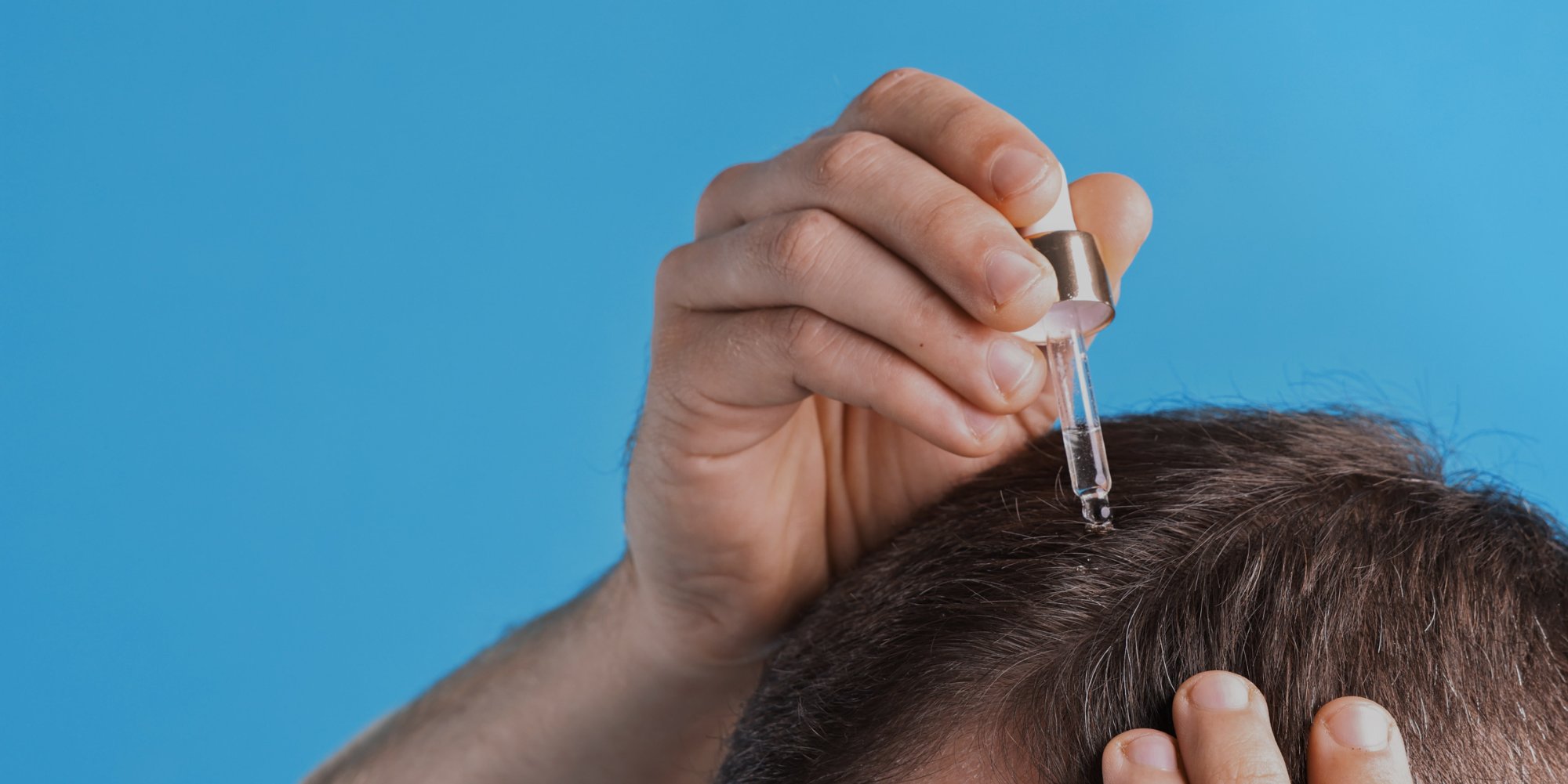 Man applying serum to scalp